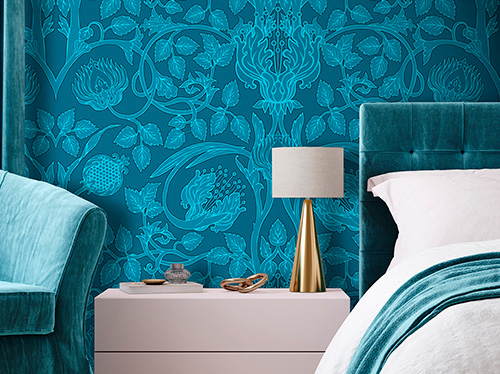 Classic wallpaper with blue floral pattern which adorns a bedroom