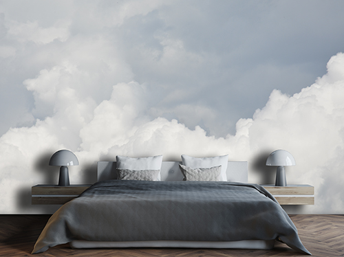 Minimal bedroom with sky and cloud wallpaper, in various shades of blue