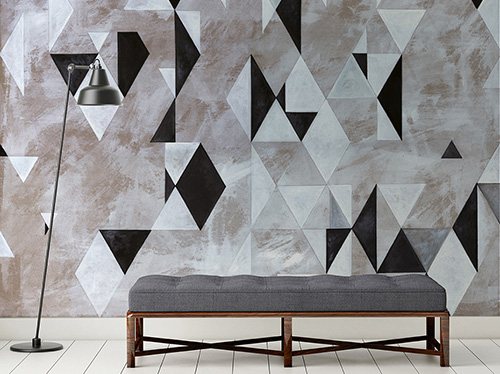 Geometric wallpaper with black and white rhombuses and triangles on a plaster-effect textured background