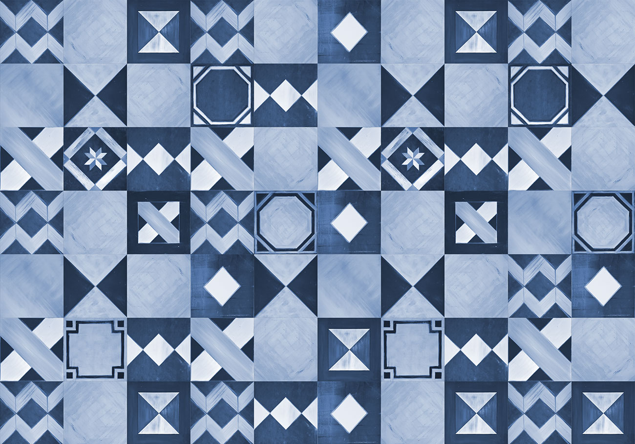 Carta da parati con piastrelle dai decori geometrici colore blu, azzurro e bianco